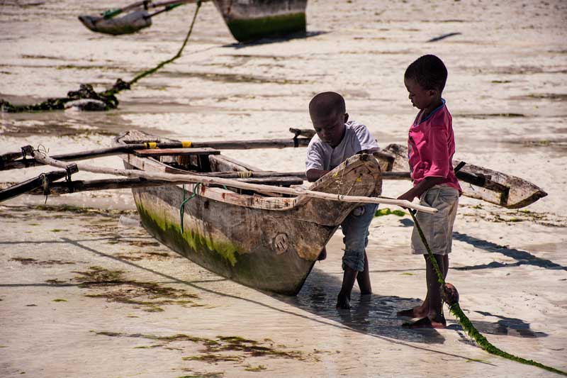 small children playing with fisherboat